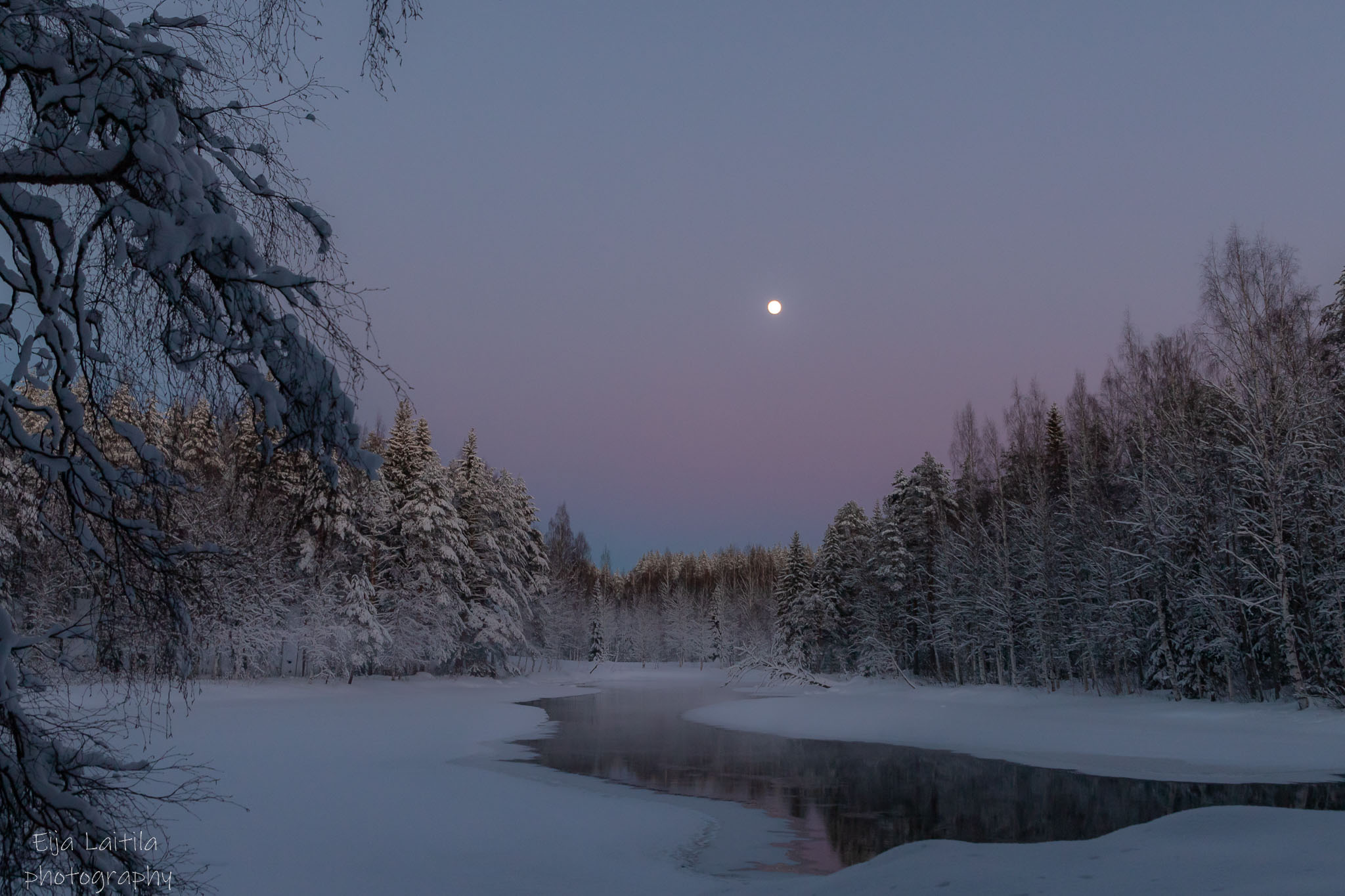 Talvinen jokimaisema kuun loisteessa