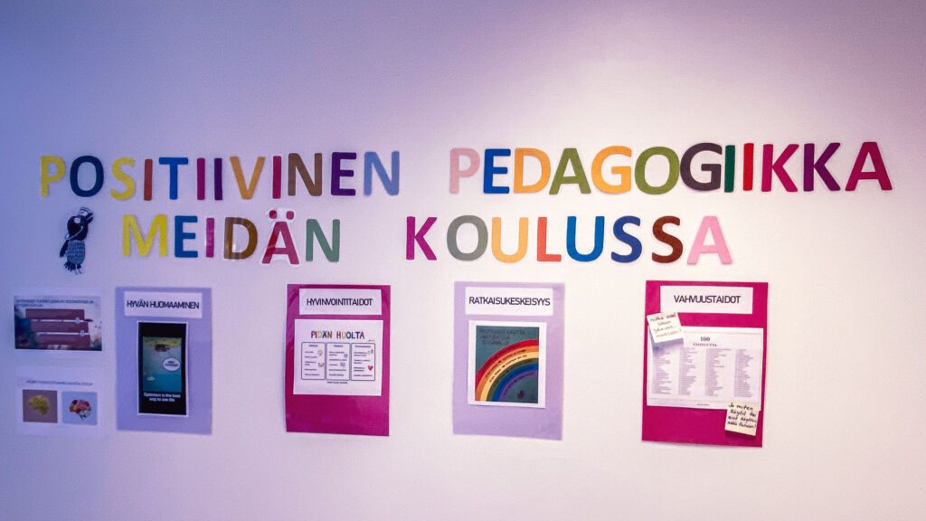 Teos koulun seinällä, jossa lukee positiivien pedagogiikka meidän koulussa. 